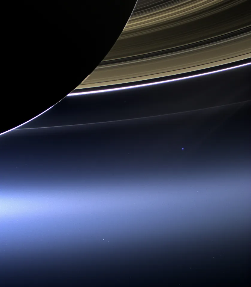 A blue dot underneath the rings of Saturn